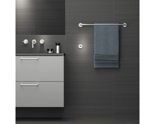 Modernes Badezimmer mit Waschbeckenunterschrank, Armaturen, Handtuchhalter und Handtuch.