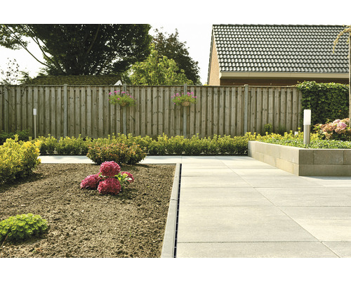 Jardin avec pavés, fleurs et clôture en bois