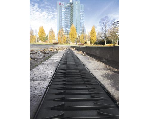 Image d''un caniveau de drainage à l''extérieur avec un bâtiment en arrière-plan.