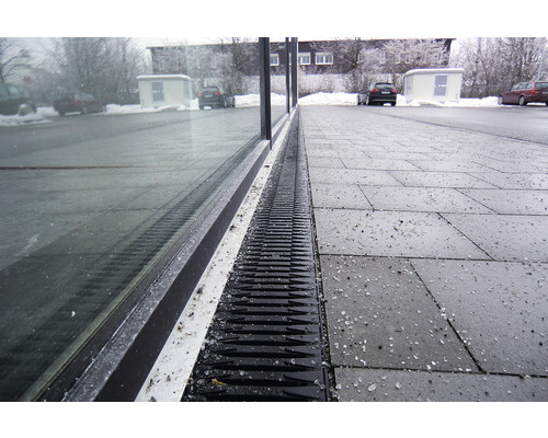 Caniveau de drainage en plastique devant un bâtiment