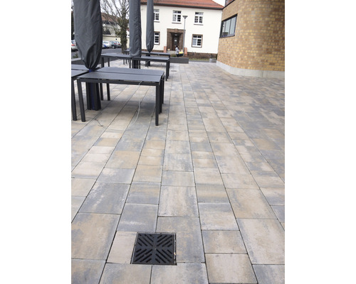 Aussenbereich mit Pflastersteinen, Tischen und Abdeckung