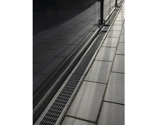 Évacuation au sol avec caillebotis à côté de pavés