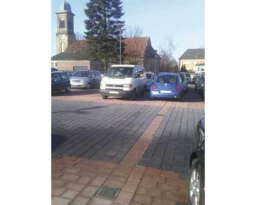 Parking avec surface pavée et voitures garées