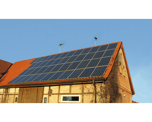 Toit de maison avec installation solaire et deux éoliennes pour la production d''énergie