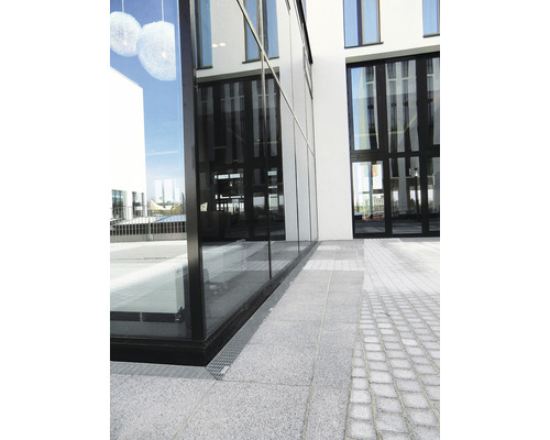 Außenansicht eines modernen Gebäudes mit Glasfassade und gepflastertem Gehweg