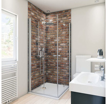 Salle de bains avec douche, lavabo et toilettes devant un mur de briques