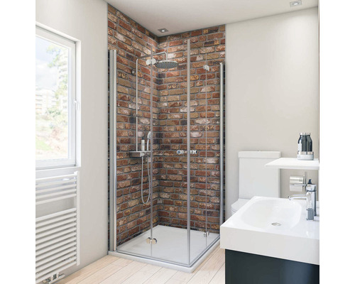 Salle de bains avec douche, lavabo et toilettes devant un mur de briques