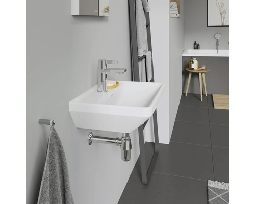 Salle de bains moderne avec lavabo blanc, robinet chromé et porte-serviettes