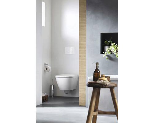 Salle de bains avec WC suspendu, brosse de toilette et tabouret en bois