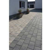 Gepflasterte Auffahrt mit Pflastersteinen und zwei Pflanzkübeln