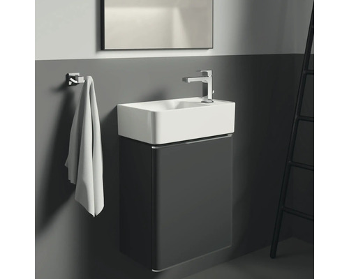 Salle de bain moderne avec meuble sous-lavabo, robinet, porte-serviettes et échelle