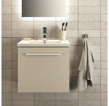 Scène de salle de bains avec meuble sous-lavabo, lavabo, robinet, miroir, serviette et accessoires de salle de bains devant un mur carrelé