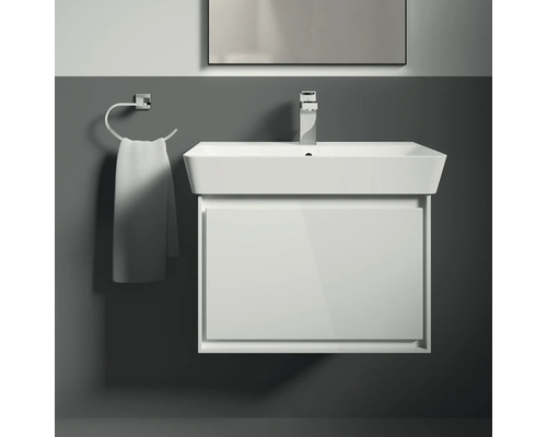 Waschtisch mit Unterschrank, Armatur und Handtuchhalter im Badezimmer.