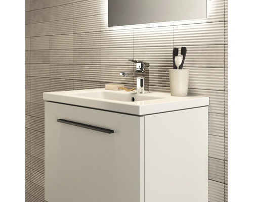 Waschtisch mit Armatur, Seife, Zahnbürsten und strukturierter Wand