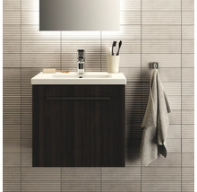 Salle de bains moderne avec meuble sous-lavabo, lavabo, robinet, serviette et accessoires de salle de bains.