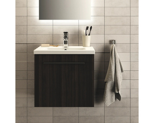 Salle de bains moderne avec meuble sous-lavabo, lavabo, robinet, serviette et accessoires de salle de bains.