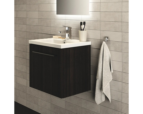 Salle de bain avec meuble sous-lavabo, lavabo, robinet et porte-serviettes sur mur structuré