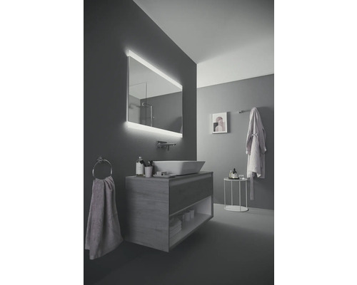 Salle de bains moderne avec miroir éclairé, meuble-lavabo et porte-serviettes