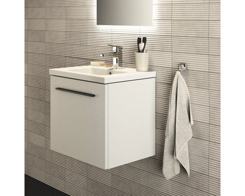 Modernes Badezimmer mit Waschbeckenunterschrank, Armatur, Handtuch und Badaccessoires.