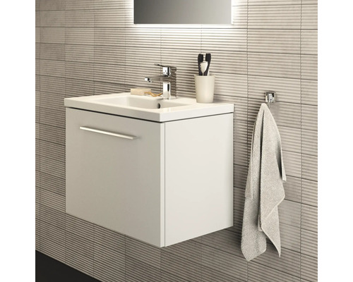 Badezimmerwaschtisch mit Waschbecken, Armatur und Handtuchhalter an strukturierter Wand