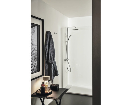 Badezimmer mit Dusche, Handtuch, Tisch und Dekoration