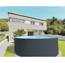 Piscine hors sol ronde dans le jardin devant une maison