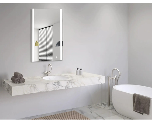 Modernes Badezimmer mit beleuchtetem Spiegel, Waschtisch mit Marmorplatte und Badewanne.