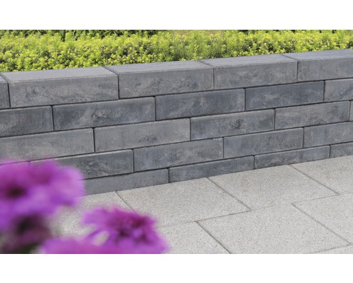 Mur gris en pierres de béton et dalles de sol dans le jardin