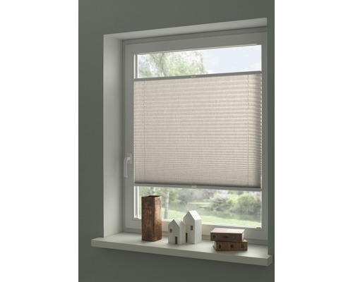 Fenêtre avec store plissé fermé et décoration sur le rebord de la fenêtre