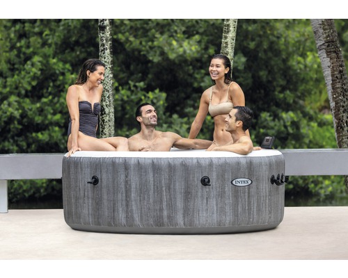 Bain à remous gonflable avec quatre personnes à l''extérieur