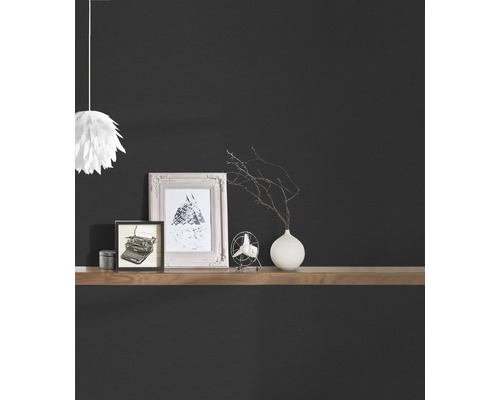 Dekorative Artikel auf einem Holzregal vor einer dunklen Wand