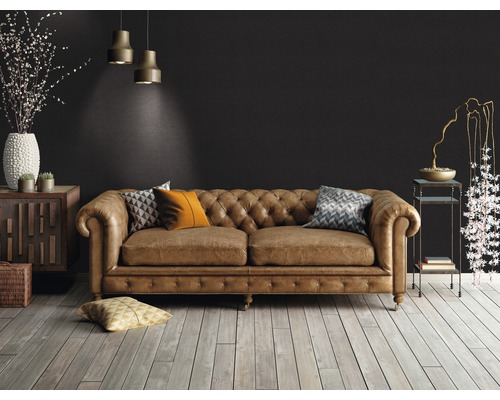 Wohnzimmer mit braunem Ledersofa im Chesterfield-Stil, Holzboden und dekorativen Elementen