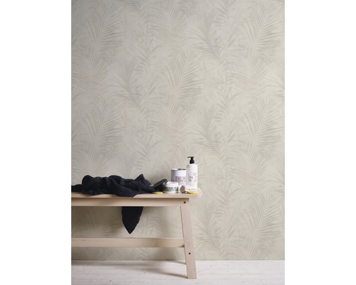 Badezimmer mit Tapete mit Palmenmuster, Handtuch und Pflegeprodukten auf einer Bank