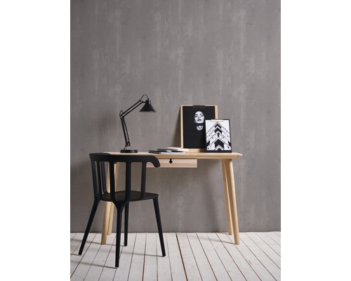 Schreibtisch mit Lampe, Stuhl und Dekoration auf hellem Holzboden