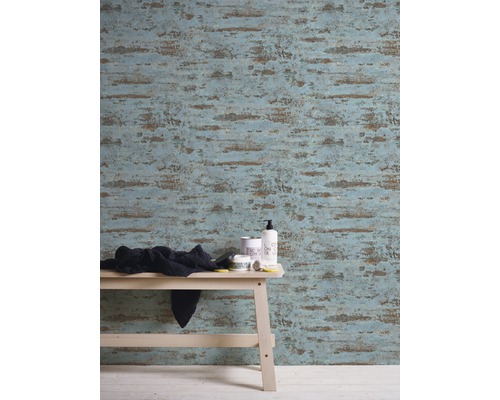 Raumansicht mit gemusterter Tapete, hellem Holzhocker und Badutensilien