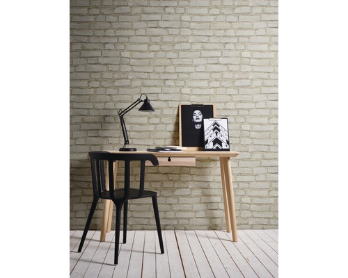 Bureau avec table, lampe de bureau et chaise devant un mur avec papier peint en briques