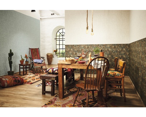 Une salle à manger avec une table en bois, des chaises et des éléments décoratifs tels que des coussins, des tapis et des plantes