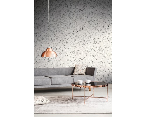 Wohnzimmer mit grauem Sofa, Tisch und gemusterter Tapete