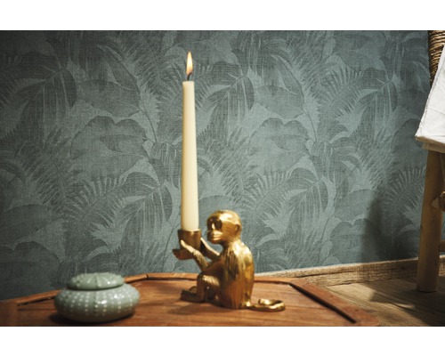 Dekorative Szene mit Kerzenständer in Affenform, Kerze, Dose und Tapete mit Blattmuster