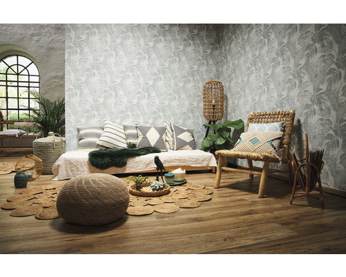 Wohnzimmer mit Tagesbett, Rattansessel, Pouf und gemusterter Tapete