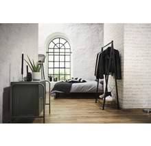 Schlafzimmer mit Bett, Kleiderständer, Kommode und großem Fenster