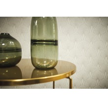 Zwei Glasvasen auf einem Tisch vor einer Wandtapete mit Art-Deco-Muster.