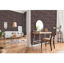 Wohnzimmer mit gemusterter Tapete, Sofa, Tisch und Dekorationen für ein gemütliches Ambiente.