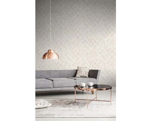 Salon avec papier peint à motifs, canapé et table basse.