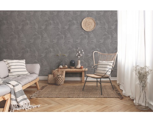 Wohnzimmer mit grauer Dschungeltapete, Sofa, Stuhl und Teppich