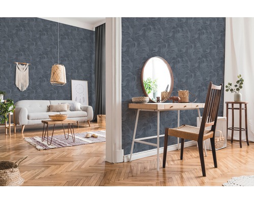 Wohnzimmer mit gemusterter Tapete, Sofa, Tisch und Stuhl.