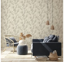 Salon avec papier peint à motifs, canapé, fauteuil et éléments décoratifs pour une ambiance chaleureuse
