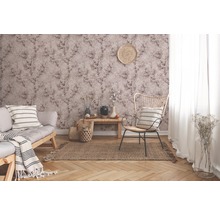 Wohnzimmer mit gemusterter Tapete, Sofa, Sessel und Teppich