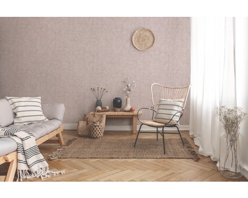 Wohnzimmer mit Sofa, Sessel, Teppich und dekorativen Elementen für ein gemütliches Ambiente