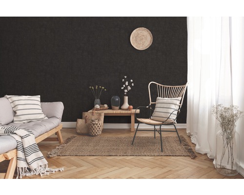 Wohnzimmer mit dunkler Wand, Sofa, Sessel, Holztisch und Teppich